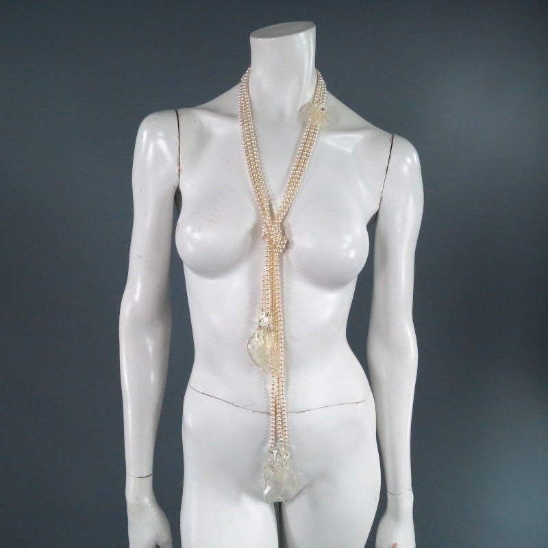Beautiful 2003's pearl strand necklace by CHANEL. A classic 1930's style, this piece comes in a long three string of pearls with clear camellia flower brooch with 