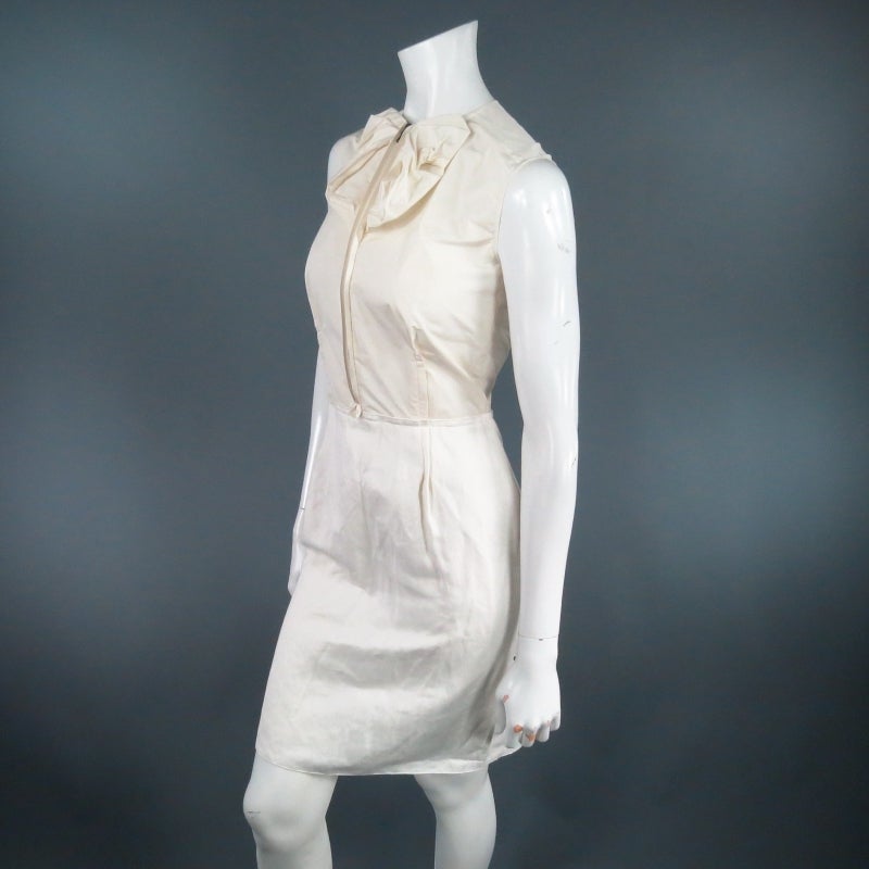 Lovely sleeveless cocktail dress by LANVIN. A fabulous creation, this piece comes with a cream taffeta bodice featuring outward darts, and exposed zipper with ruffled bow detail along the neckline and off white pencil skirt with ruffled fish tail.