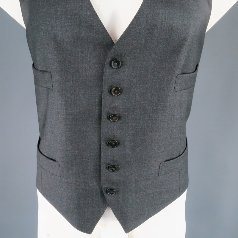 Six button vest by TOM FORD. This piece comes in a  dark charcoal wool with pinstripe silk lining and features four slit pockets and adjustable back detail. Great addition to any suit. Made in Italy.
 
Excellent Pre-Owned Condition
 
Tag size: