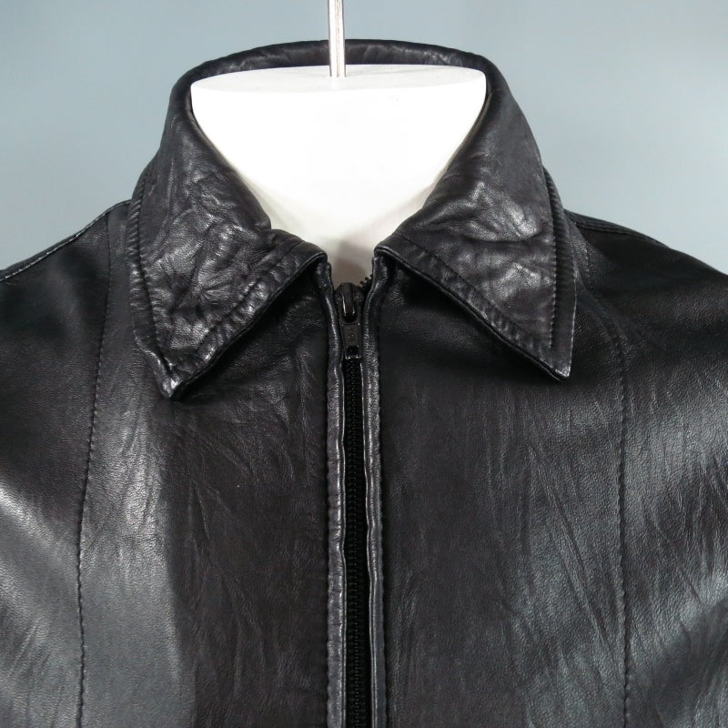 COMME des GARCONS Jacket consists of leather material in a black color tone. Designed with a wrinkled press appearance, front zipper closure and tone-on-tone stitching throughout body. Includes 2 side front pockets, double button sleeve-cuff closure