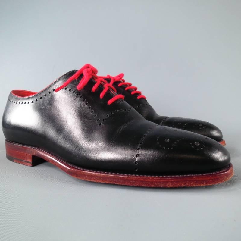 KITON Lace Up Shoe consists of leather material in a black color tone. Designed with a round-toe front, wing-tip detail, perforated accents toward vamp section and contrast red laces. Tone-on-tone stitching can be seen around edges with red leather
