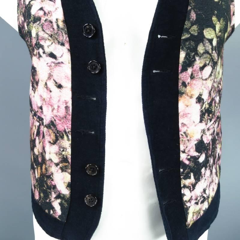 Stunning reversible vest by ANN DEMEULEMEESTER. This piece is made of cotton, one side has a beautiful floral print with black trim, the other side is solid black. The floral side features four buttons and two slit pockets. The solid black side has
