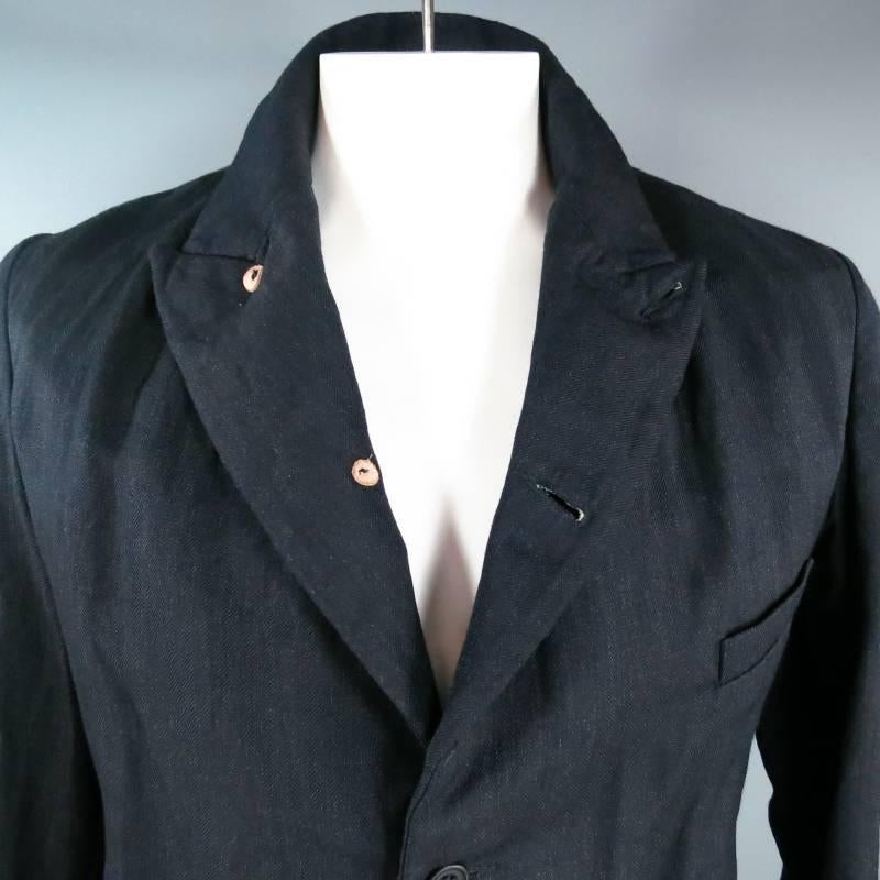 Classic twist soft shoulder sport coat by PAUL HARNDEN. This piece comes in a navy blue wool linen herringbone fabric with wrinkled texture and features a peak lapel, two button closure with full button option, breast and flap pockets, and closed
