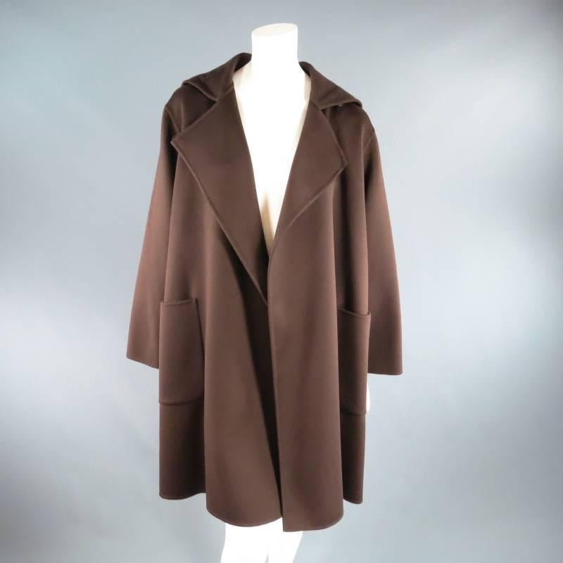 Fabulous oversized silhouette winter shawl coat by MAX MARA. This ultra chic style comes in a soft rich brown cashmere and features a wrap and button closure, large patch pockets, and hood. Perfect cozy piece for winter winter weather layering. Made