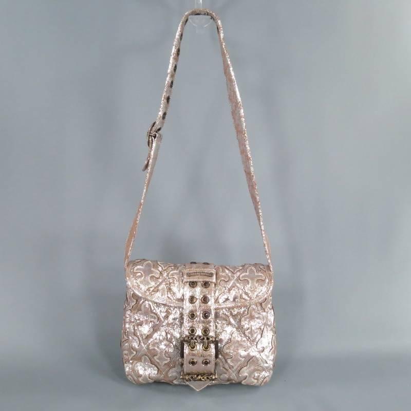 Fabulous shoulder bag by CHROME HEARTS. This fun rock & roll style comes in metallic silver textured leather that is quilted and appliqued with Fleur de Lis patches and features a a flap with grommet belt closure with oversized engraved stearling