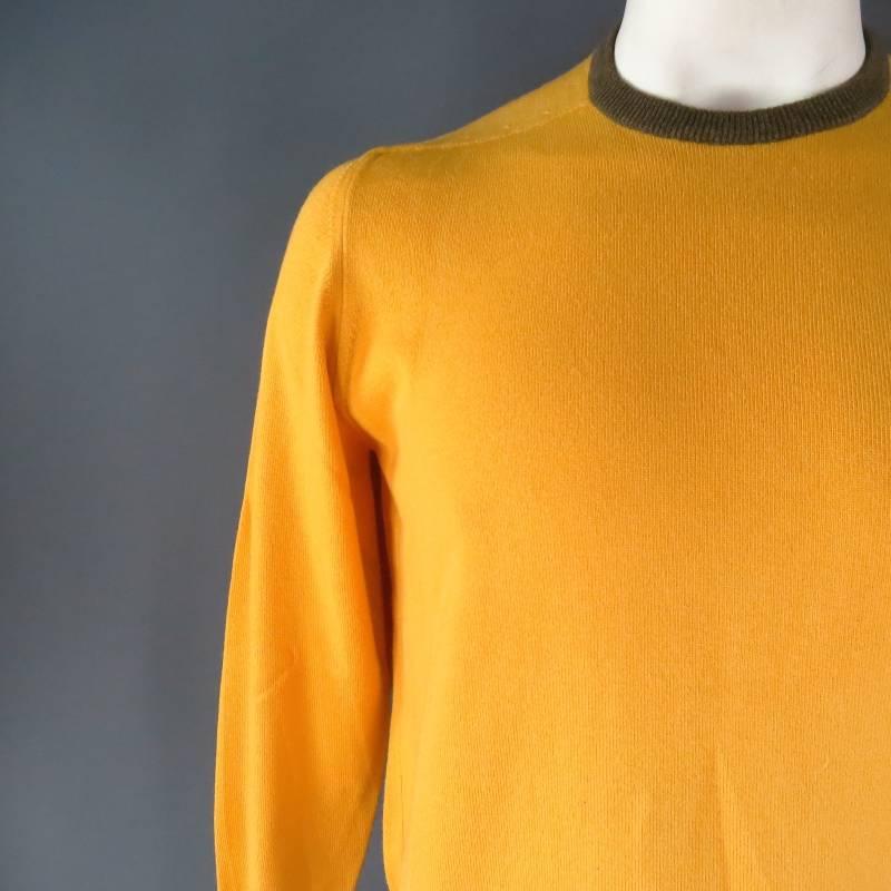 Loro Piana Pullover consists of cashmere / cotton blend material in a yellow color tone. Designed with crew-neck collar that accents grey trim, tone-on-tone stitching along shoulder inseam, ribbed cuffs with blousen hem. Made in Italy.
 
Good