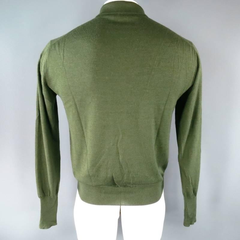 Loro Piana Pullover consists of cashmere / silk blend material in a forest green color tone. Designed with a pointed collar, 3-button front, tone-on-tone stitching along shoulder inseam, ribbed cuffs with blousen hem. Made in Italy.
 
Good