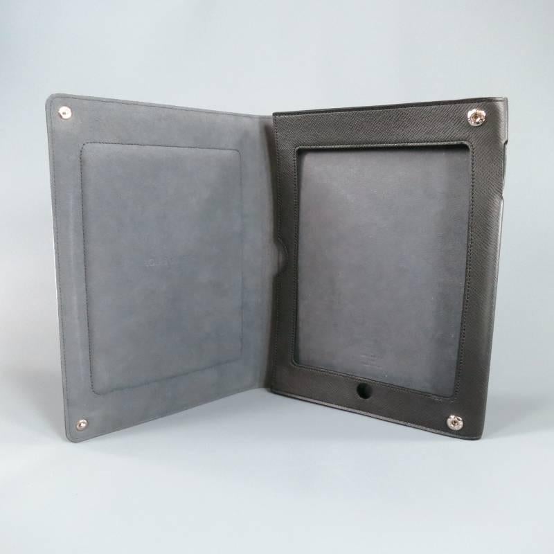 Louis Vuitton iPad 2 Case-Cover consists of leather material in a charcoal-black color tone. Designed with silver snap closures, embossed 'LV' logo on bottom right corner, tone-on-tone stitching all-around edges in 'taiga' textured leather. Case