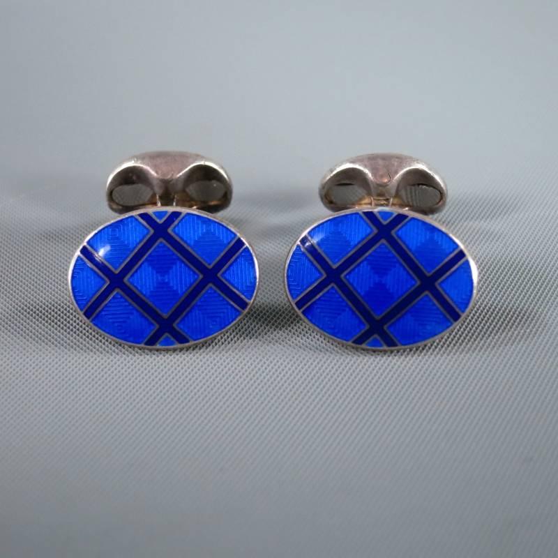 Tiffany & Co. Cuff Links consists of 'Sterling Silver' material in a deep blue color tone.
Designed in an oval shape, checkered pattern runs across surface with a solid silver back. Snap back makes for easy placement on shirt cuff. Engraved 2003