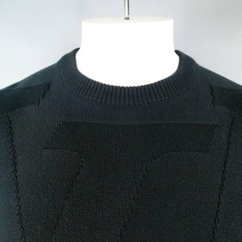 Unique black pullover sweater by LOUISE VUITTON. This rare style comes in a a medium weight cotton knit and features a crew neck, ribbed neck, wrist, and waist bands, and oversized LV logo knitted in an embossed effect through the front. Made in