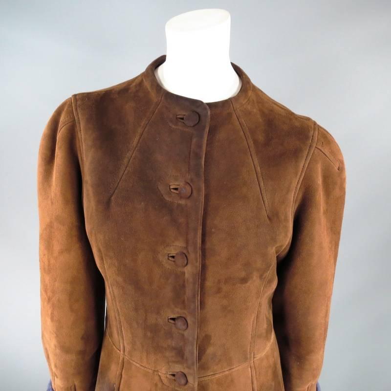 Vintage winter coat by HERMES. This rare and unique style comes in a medium tan brown suede with purple shearling liner and features a sleek collarless neck, suede covered eight button closure, slight tapered puff sleeve, fitted top with a line