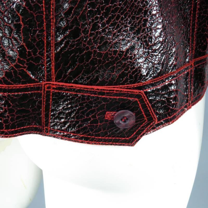 Awesome zip trucker jacket by ROBERTO CAVALLI. This piece comes in a unique glossy black and red coated crackle leather and features classic trucker jackjet details with a modern take, pointed collar, zip closure, frontal pockets, chest seam, red