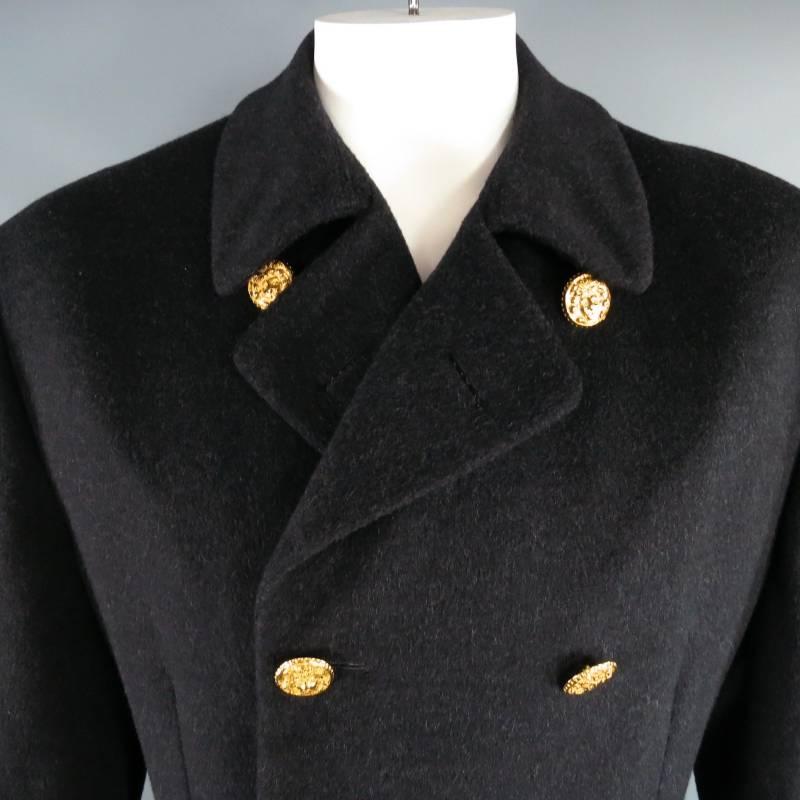 This rare archive piece by GIANNI VERSACE comes in a soft textured charcoal wool and features a classic double breasted peacoat lapel with large yellow gold Medusa buttons, frontal flap pockets, single vent back, and back waist belt. Made in