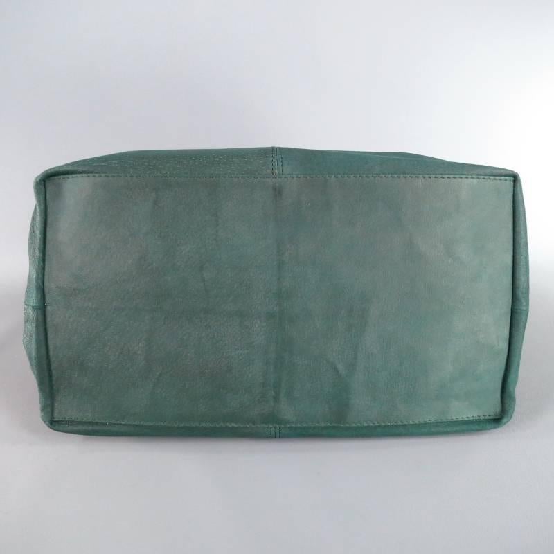 Rare shoulder tote bag by DONNA KAREN. This chic style comes in a soft emerald forest green leather and features gold tone snap  closure, flat base, and back tied rope strap with gold grommets. Includes Dust Bag. Made in Italy.
 
Excellent