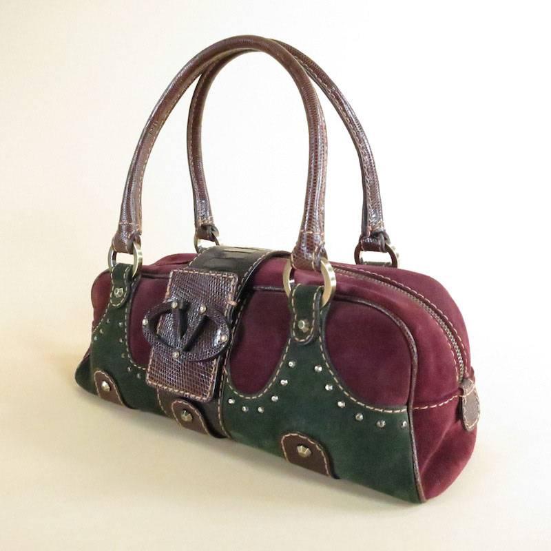 This gorgeous burgundy Valentino bag is adorned with classic brown snakeskin detail and gold toned studs. Snakeskin top handles, front flap and logo buckle.  
 
Measurements:
Size: 5
