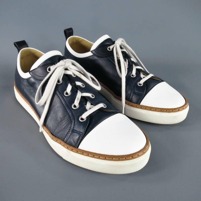 HERMES sneakers consists of leather material in a two-tone navy and white color tone. Designed with a two-tone color blocked style, round front, white cap-toe detail, tan trim all around edge. Tone-on-tone stitching throughout vamp and body, silver
