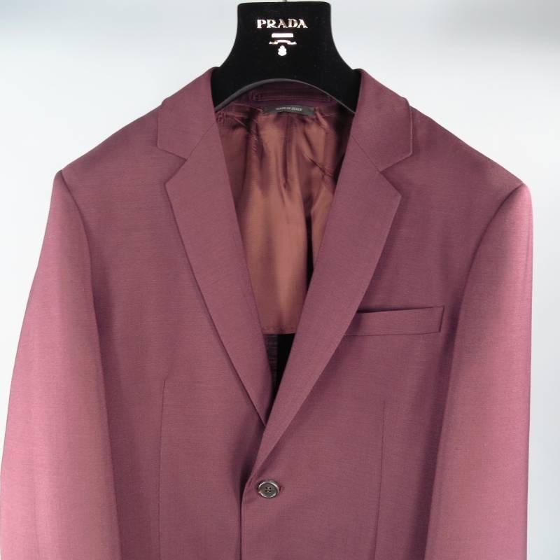 Prada Suit consists of mohair/wool material in a burgundy color tone. Designed with a slim notch lapel collar, 2-button front, tone-on-tone stitching throughout body with top inseam pocket and 2 bottom flap pockets. Detailed with 4-button cuff on
