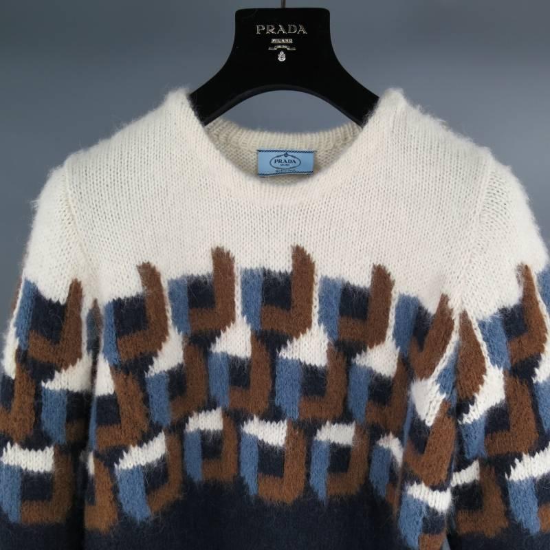 Prada Sweater consists of baby alpaca fur in a navy and cream color tone. Designed in a color blocked woven detail, cream tone can be seen toward shoulders, navy tone on bottom hem and end of sleeves. Detailed with light blue, tan and navy on mid