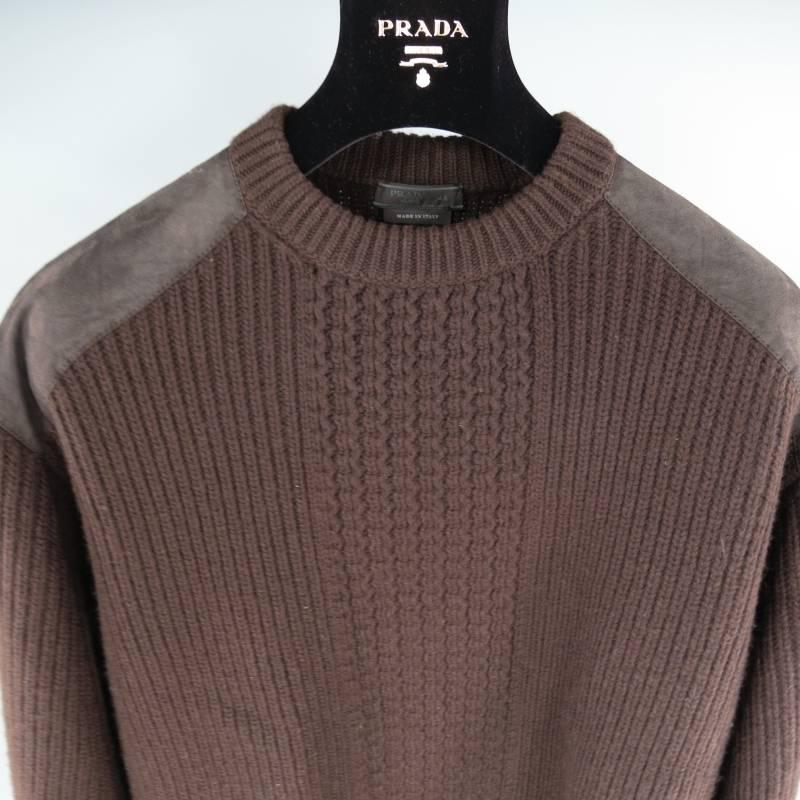 Prada Sweater consists of wool material in a brown color tone. Designed with a crew-neck collar, suede shoulder panels and tone-on-tone stitching throughout suede. Detailed with a woven mid-section, stripe ribbed pattern and blousen hem. Made in
