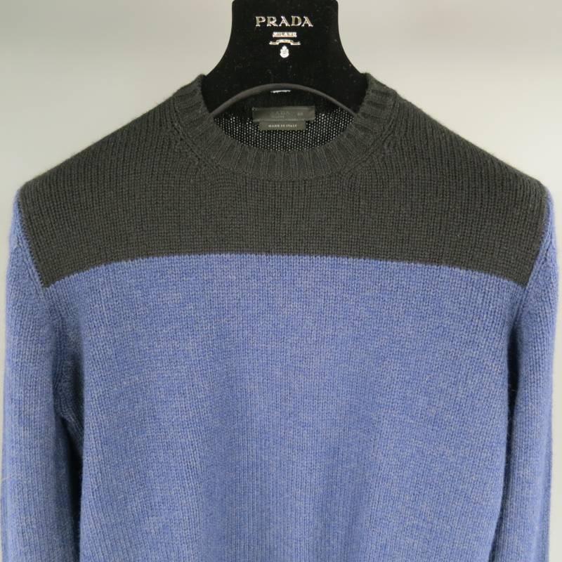 Prada Sweater consists of wool material in a Blue and Black color tone. Designed with a crew-neck collar, 2 tone color blocked pattern with shoulder/chest section in black and body in blue. Ribbed detail can be seen on cuff and collar. Made in