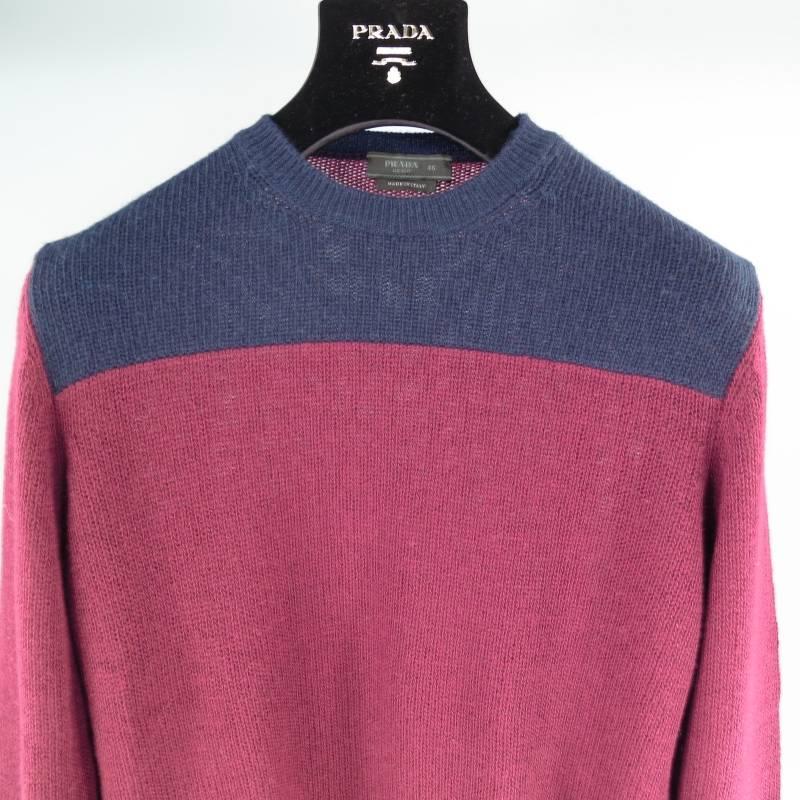 Prada Sweater consists of wool material in a Burgundy and Navy color tone. Designed with a crew-neck collar, 2 tone color blocked pattern with shoulder/chest section in navy and body in burgundy. Ribbed detail can be seen on cuff and collar.
Made