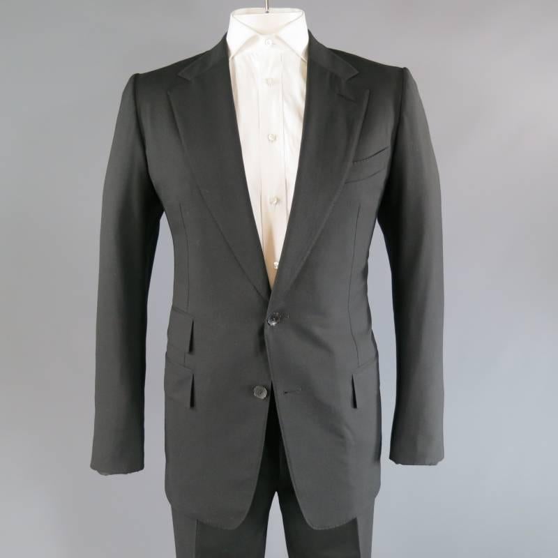 Tom Ford Suit consists of 100% wool material in black color tone. Designed with a notch lapel collar, 2-button front, tone-on-tone stitching that can be seen toward mid-section. Top inseam pocket square, multiple bottom flap pockets that feature
