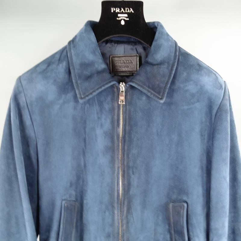 Prada Jacket consist of suede leather material in a navy color tone. Designed in a bomber style fit, silver zipper opening, tone-on-tone stitching throughout body with bottom blousen hem. Detailed with side inseam pickets, silk lining and 2 inside