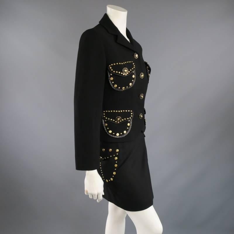 This iconic vintage GIANNI VERSACE circa 1993 runway suit comes in a black wool and features a cropped notch lapel jacket with a four gold and black Medusa button closure, and four flap patch pockets with gold Medusa and cone studs, and a matching