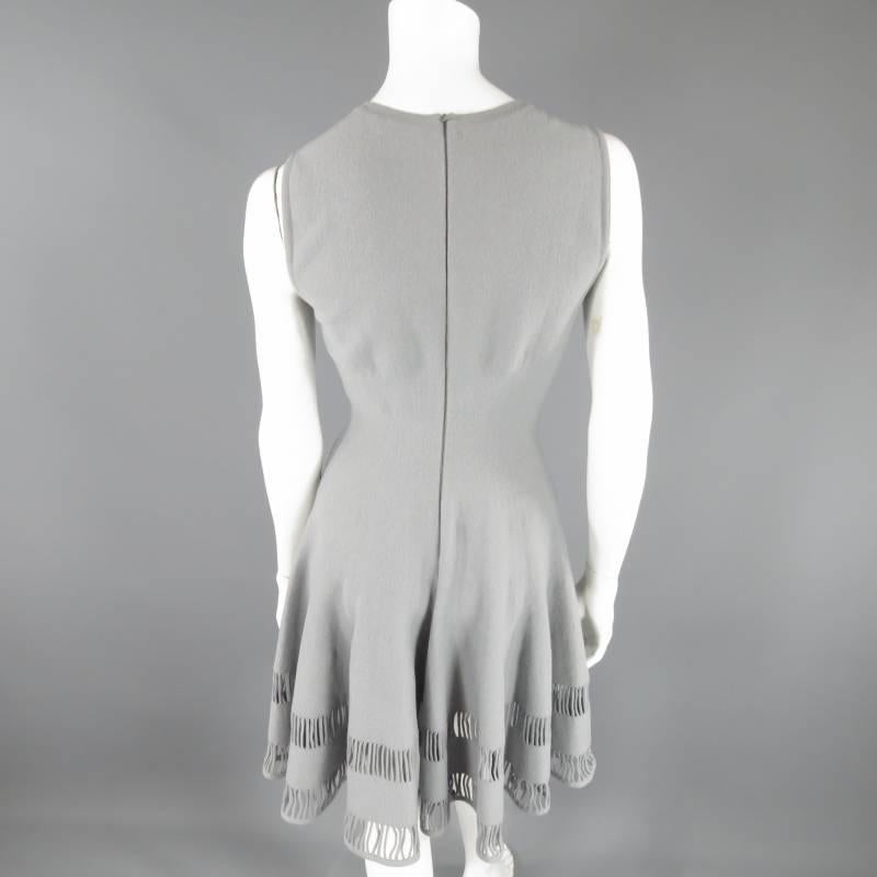 This ultra chic ALAIA dress comes in a silver grey stretch wool blend and features a square neckline, cinched waist, and fill A line circle skirt with striped slit cut out hem. Made in Italy.
 
Very Good Pre-Owned Condition.     Marked: 42
