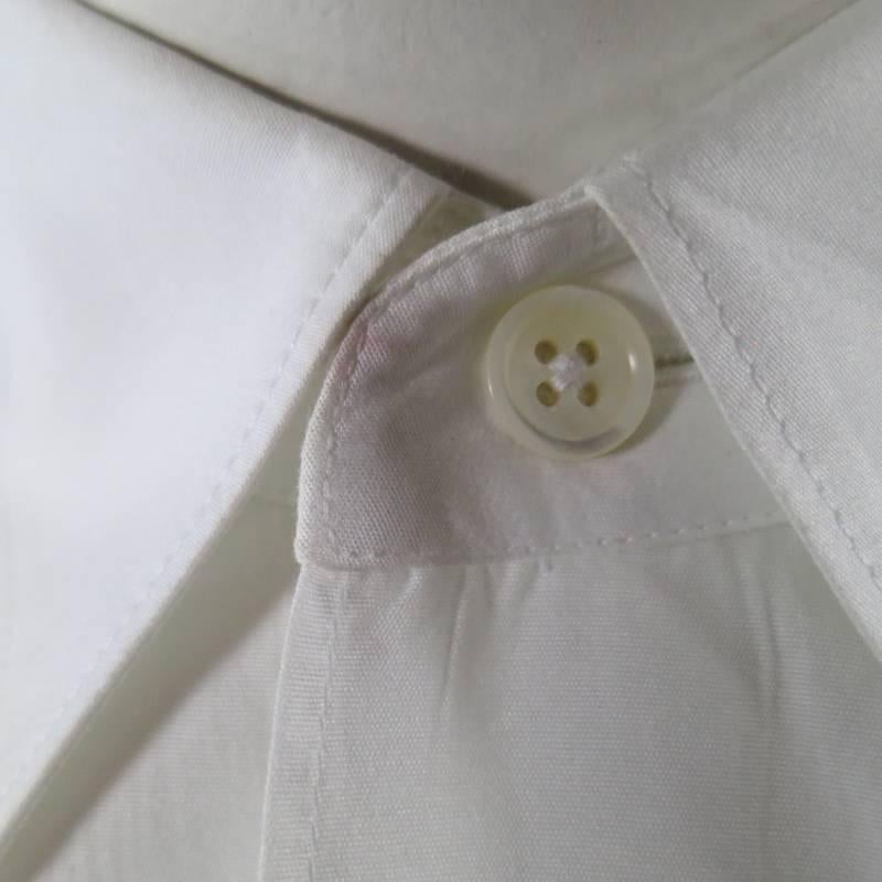 COMME DES GARCONS Long Sleeve Shirt consists of cotton material in a white color tone. Designed with black seam stitching's along shoulder and back. Slim pointed collar, chest patch pocket and single button cuffs. Made in France.
Fair Pre-Owned