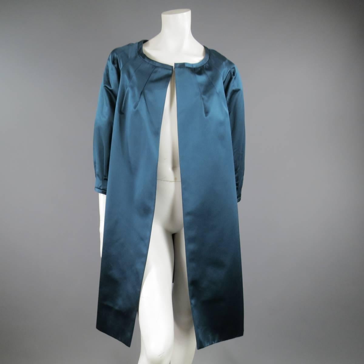 This gorgeous BARBARA TFANK evening coat comes in a teal silk satin and features a round neck, open front, three quarter pleated puff sleeves and A line silhouette.Made in USA.
 
Very Good Pre-Owned Condition.
Marked: 6
 
Measurements:

