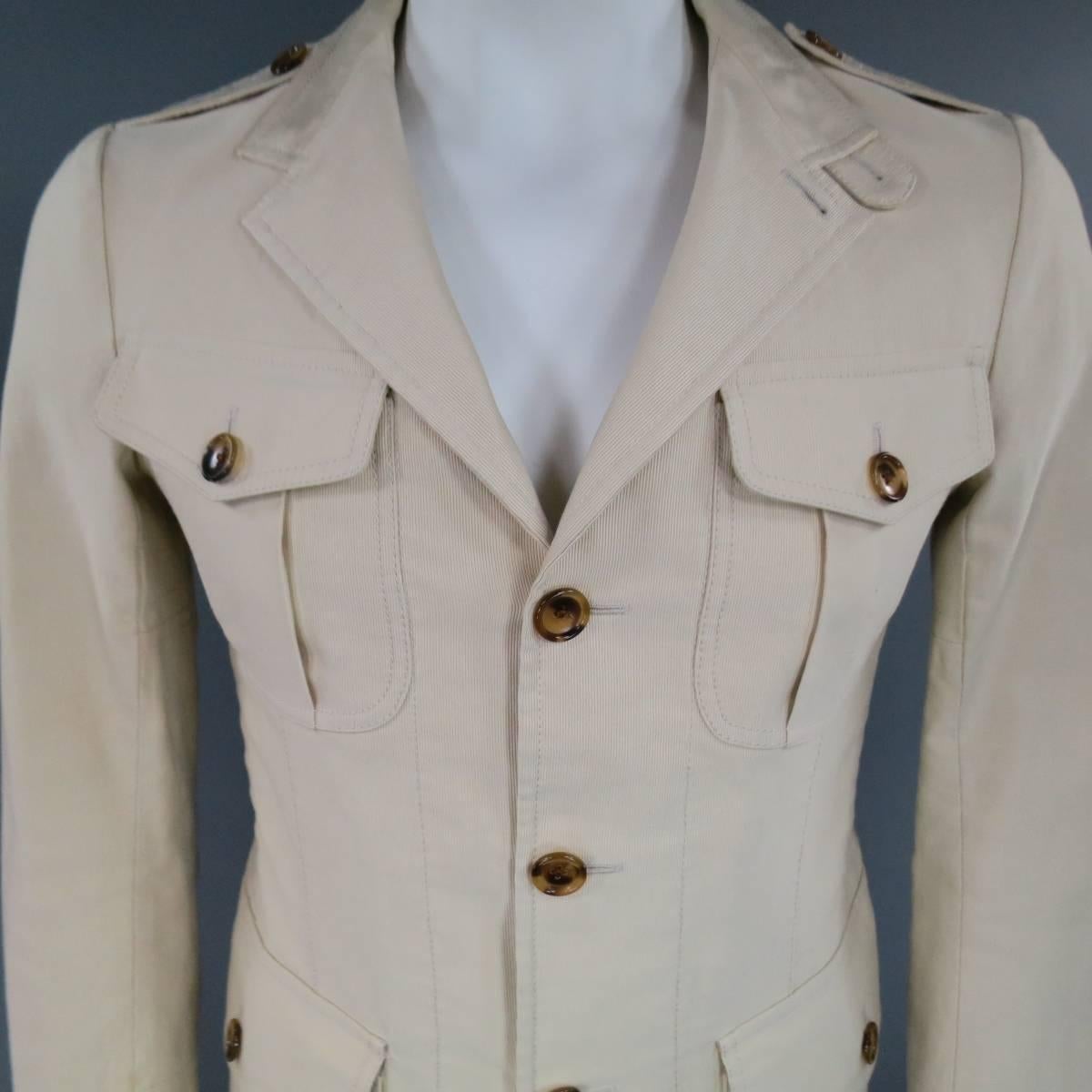 TOM FORD Jacket consists of cotton material in a rich beige / khaki color tone. Designed in a safari style, notch lapel collar with a 3-button front. Multiple patch pockets detail the top and bottom with button closures. Single button cuff and vent.