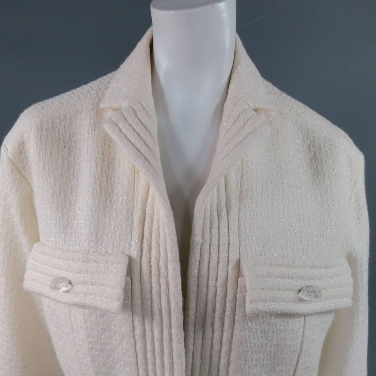 This fabulous oversized CHANEL jacket comes in a sparkley textured cream wool blend material and features a small collar lapel, open front, double patch flap pockets with clear crystal buttons, three quarter sleeves with ribbed stripe cuff, and