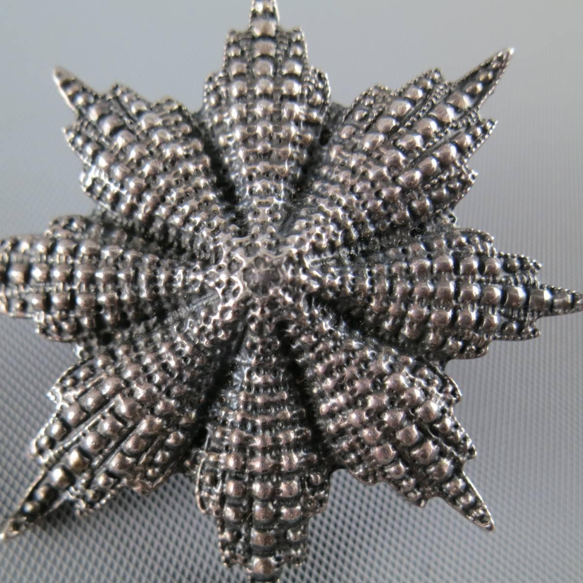 UGO CACCIATORI pin in sterling silver with an abstract flower shaped star beam motif.
 
Good Pre-Owned Condition.
 
Width: 2 in.


Web ID: 82031 