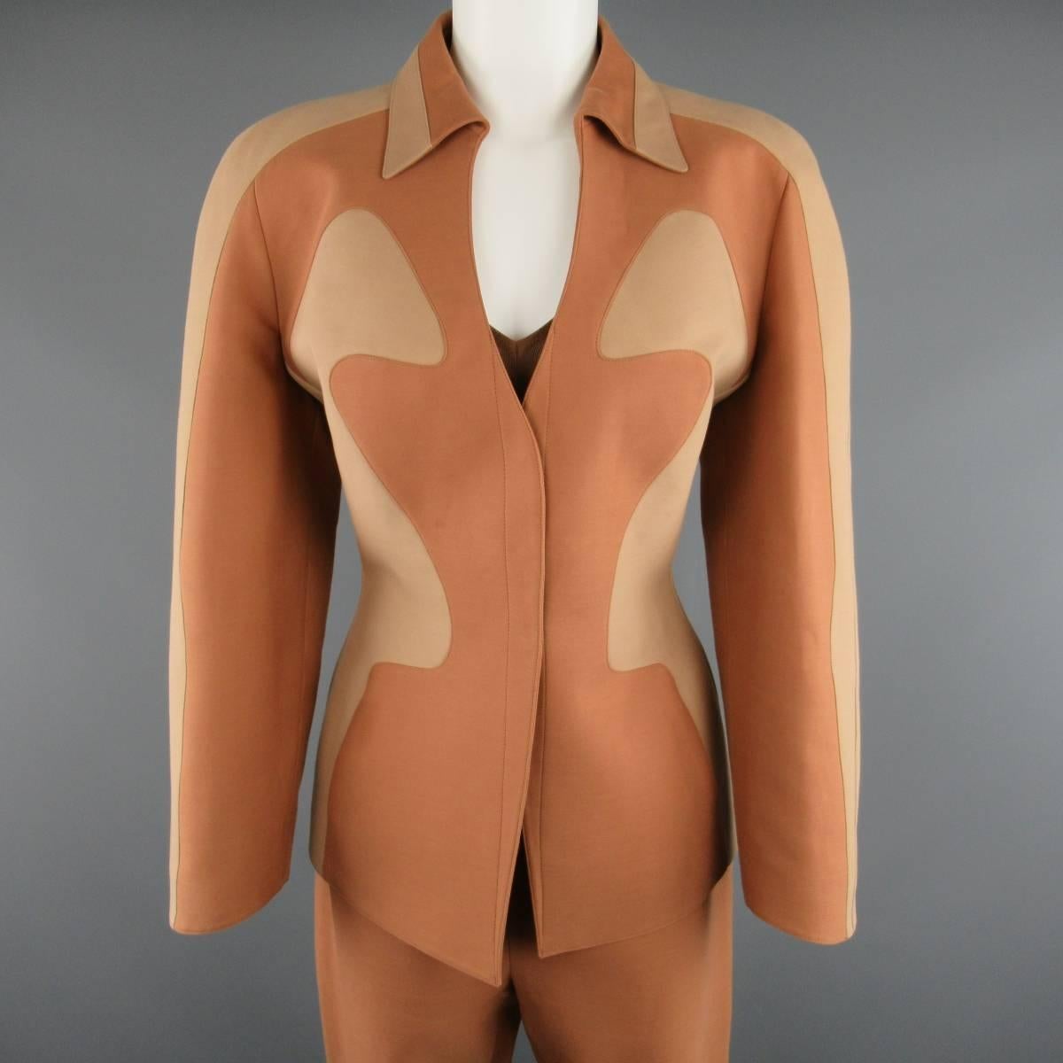 This rare THIERRY MUGLER COUTURE ensemble circa 1980's comes in a rich tan structured cotton fabric and includes an impeccably hourglass structured jacket with two tone beige panels, pointed collar, V neckline and snap closure, short sleeved sheer