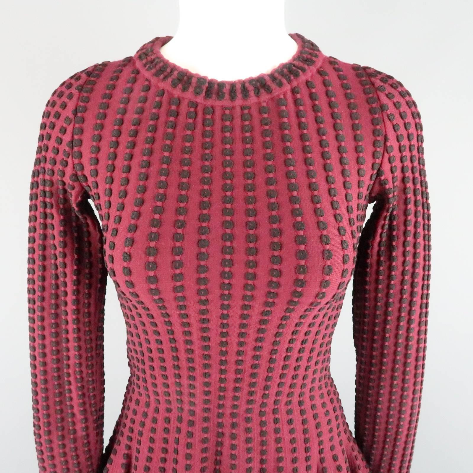 This gorgeous ALAIA long sleeved fall winter cocktail dress comes in a burgundy and black spotted textured stretch wool knit and features a high crew neck line and fit flair silhouette with pleated A line skirt.  Made in France.
 
Excellent