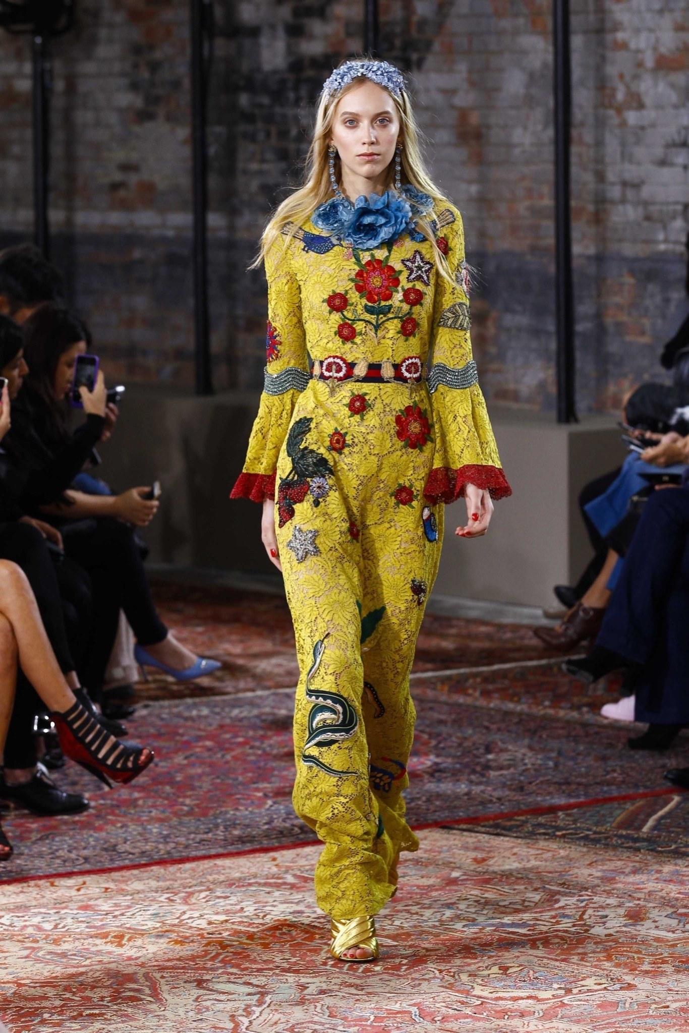 This fabulous Gucci Cruise 2016 Collection statement gown / dress retailed at $21,000.00 - comes in chartreuse yellow lace and features a round neck with detachable blue flower brooch, symmetrical blue bird and floral patches, bell sleeves with