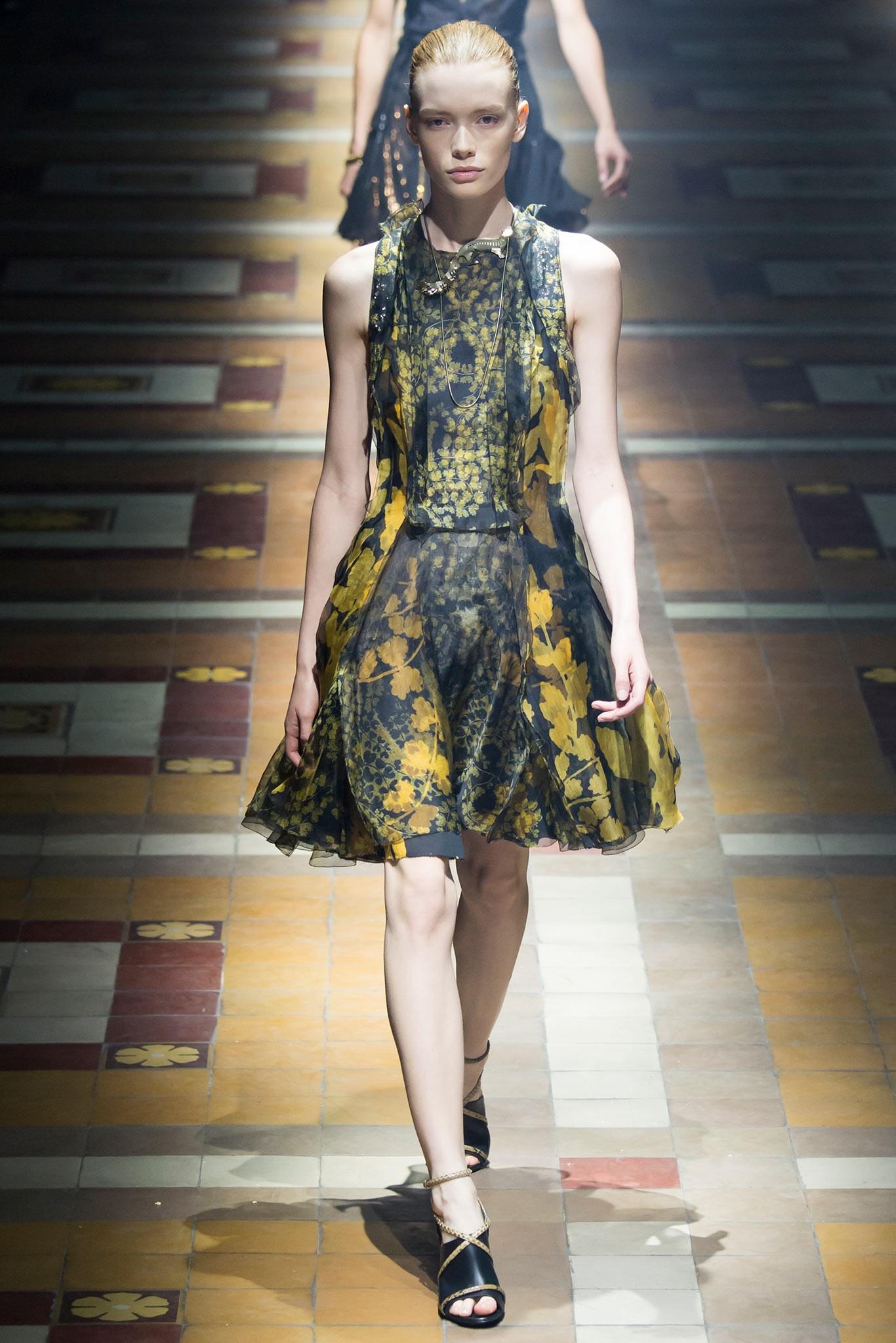 Lanvin sleeveless cocktail dress comes in layered panels of abstract olive green and gold floral print silk chiffon and features a layered bodice with ruffled accents, sequin inner panel back, and flared panel skirt. Look 41 of Spring/Summer 2015