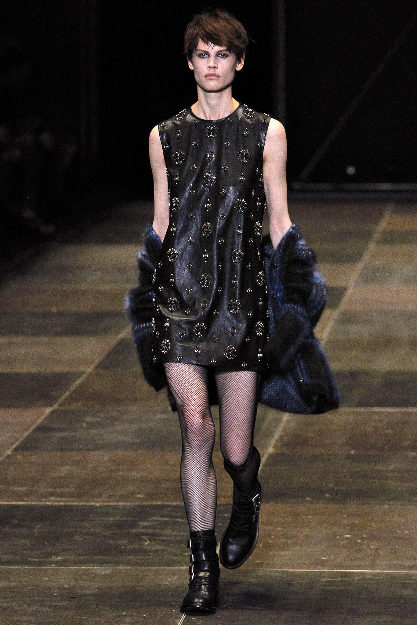 Saint Laurent Fall 2013 cocktail dress by Hedi Slimane comes in supple black leather with a round neckline, shift silhouette, and black and silver tone rhinestone and spike stud ornate embellishments throughout. Made in Italy.
 
Excellent Pre-Owned