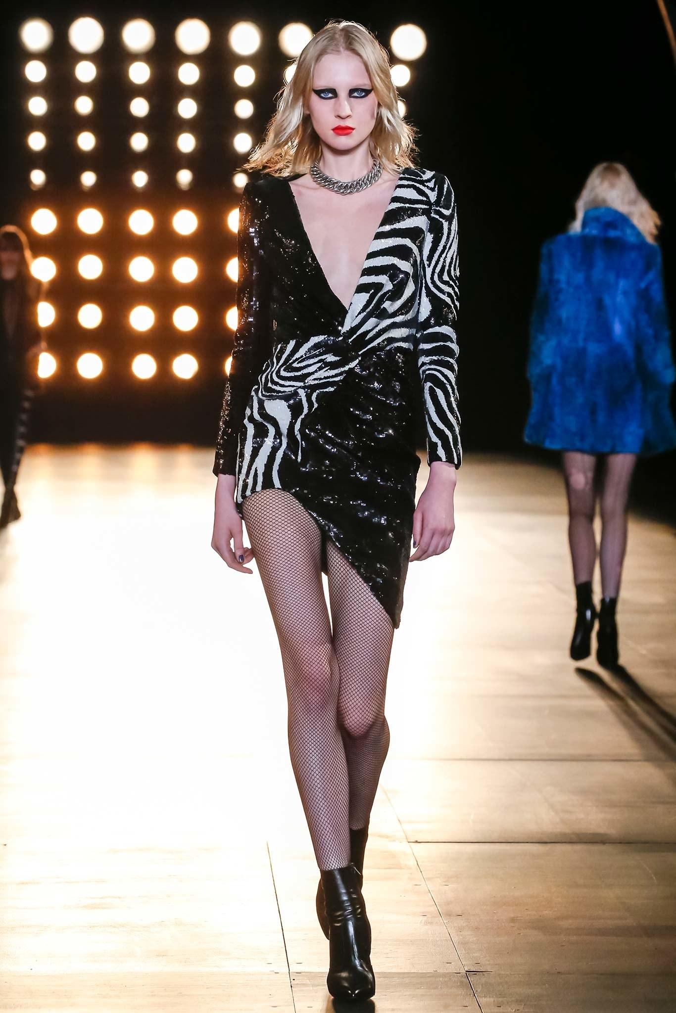 Saint Laurent by Hedi Slimane long sleeve cocktail dress comes in black wool covered in various black sequin with a faux wrap, gathered front, v neckline, padded shoulders, asymmetrical hem, and sequin zebra print panels. Worn once. Fall Winter 2015