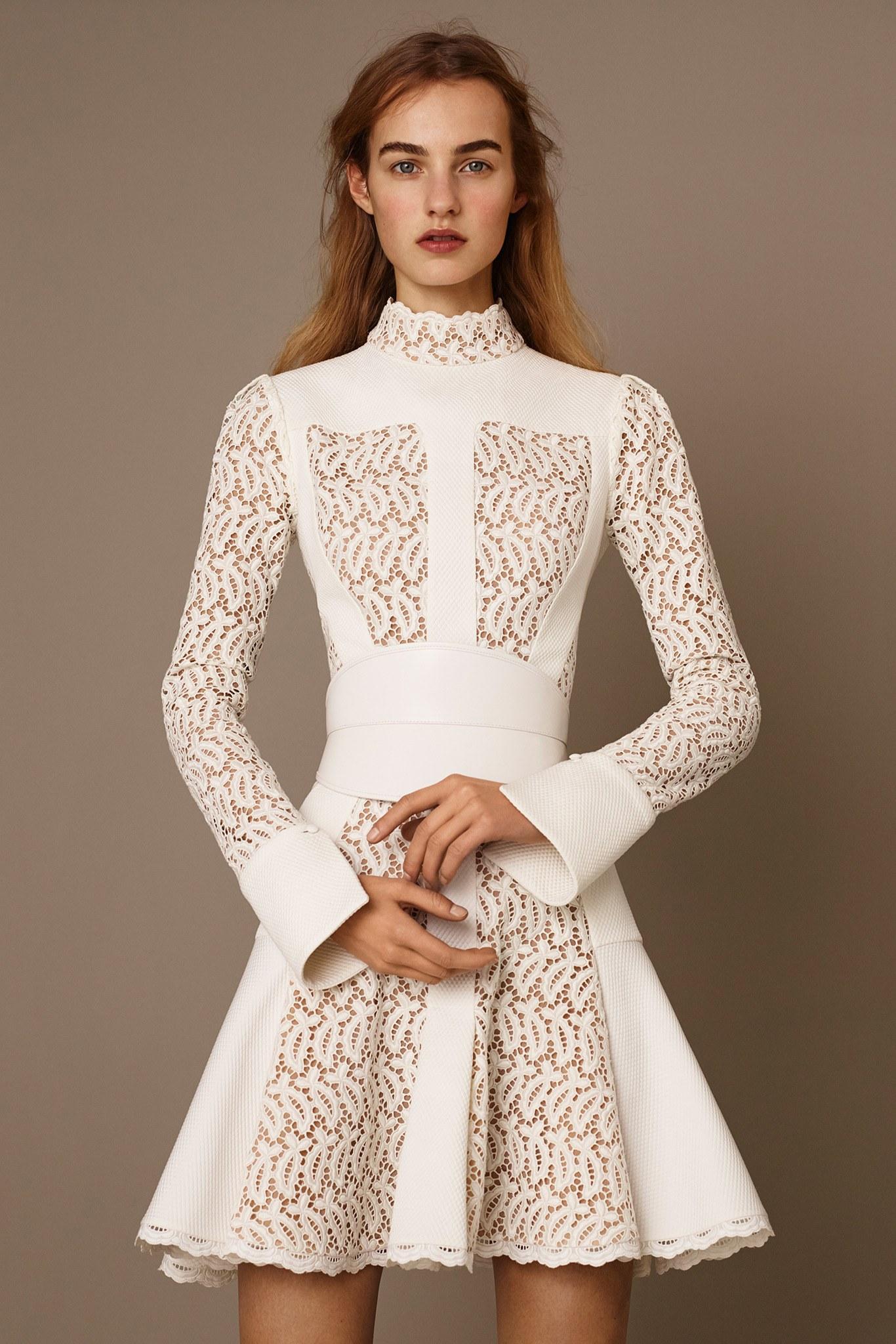 ALEXANDER MCQUEEN Pre-Fall 2015 cocktail dress comes in a cream textured fabric with lace insert panels, high lace stand up collar, long sleeves with folded cuffs, drop waist pleated skirt, and tan beige liner. Belt available separately. Made in