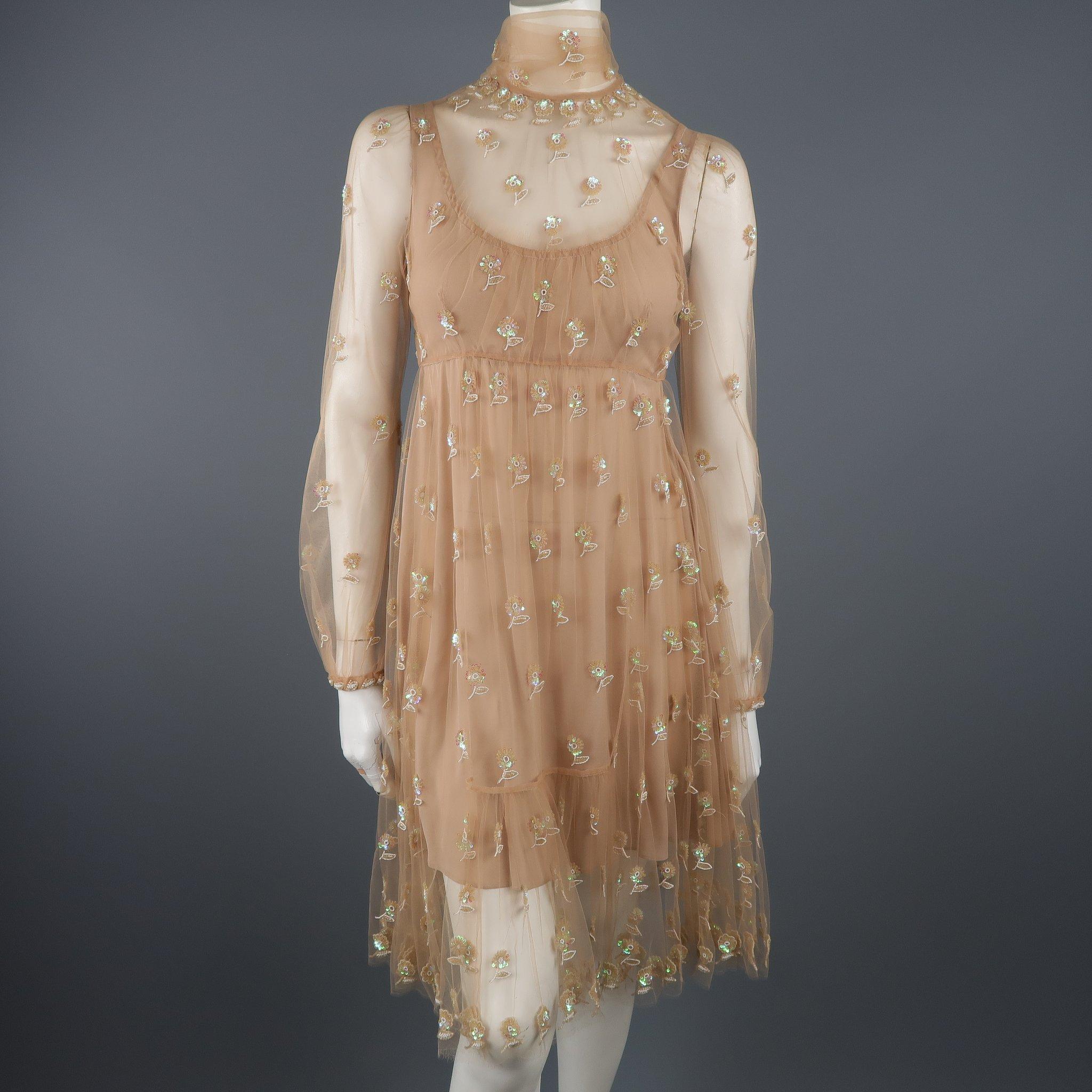 Valentino cocktail dress comes in tan tulle with all over beaded floral pattern, tied scarf neckline, long sleeves, full skirt, and silk lining. Made in Italy.
 
Excellent Pre-Owned Condition.
Marked: (no size)
 
Measurements:
 
Shoulder: 12