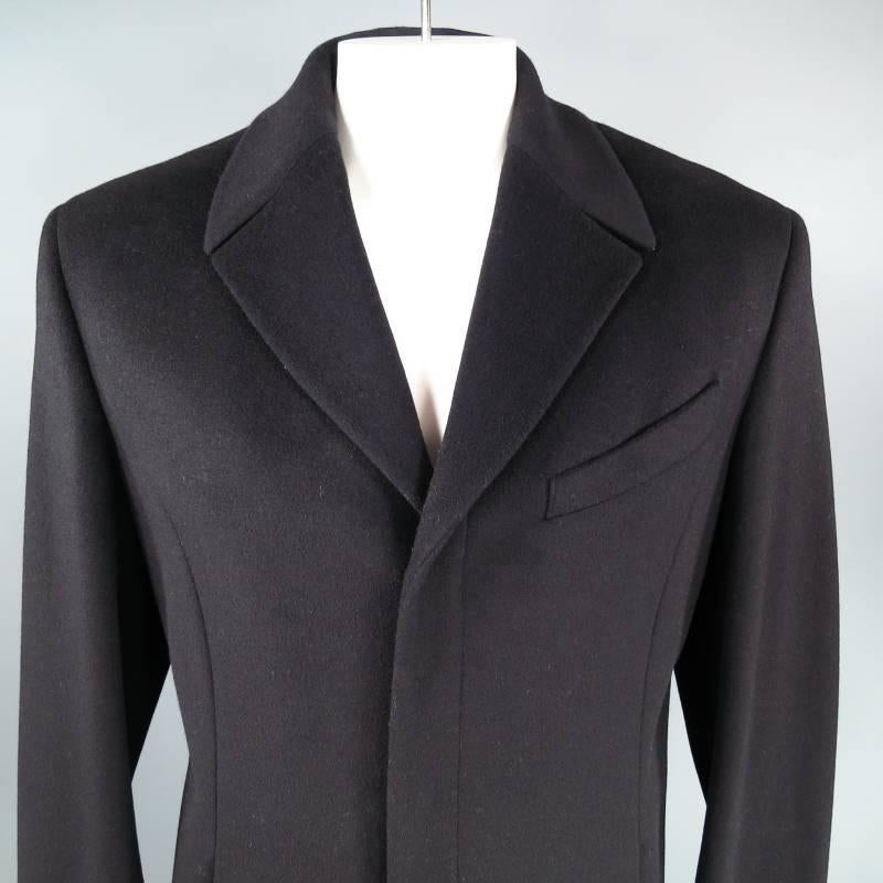 Trench coat by THIERRY MUGLER is made of a black wool blend. This unvented jacket features hidden front snap buttons, two hidden slit pockets, peak lapel, and a thick back belt with decorative snap buttons. Made in Italy.
 
Excellent Pre-Owned
