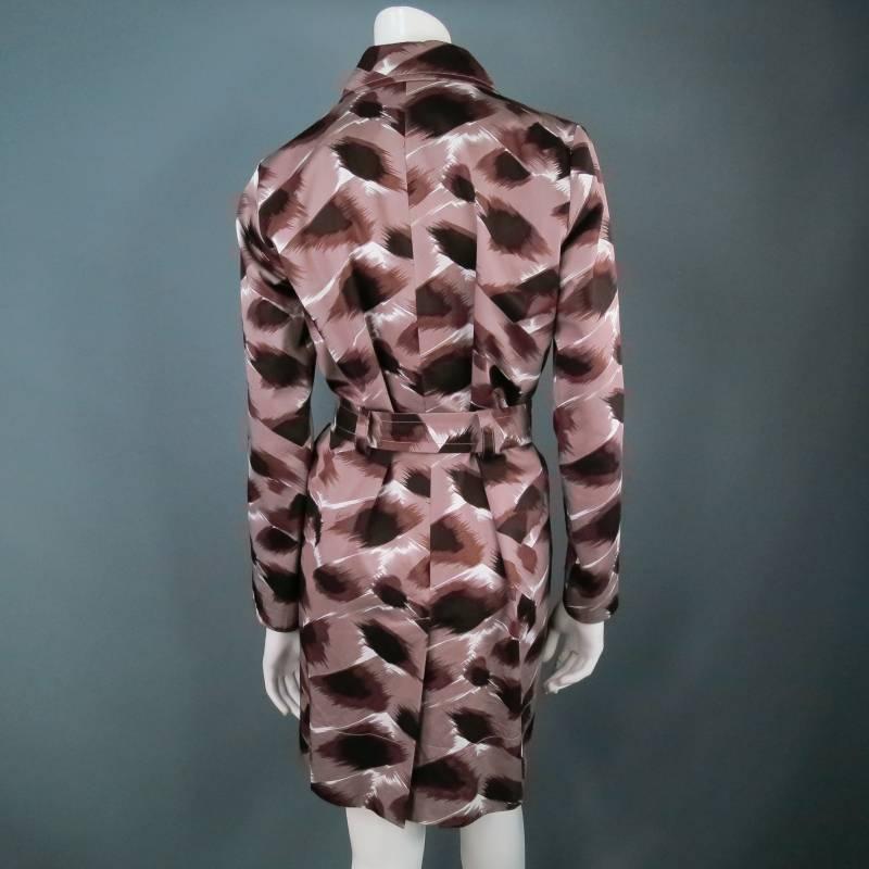Chic taupe cotton trench coat by GUCCI. In a fabulous all over animal print resembling cheetah or leopard, featuring concealed buttons, gold hardware, and waist belt. A functional garment that is effortlessly glamorous. Made in Italy.
 
Excellent