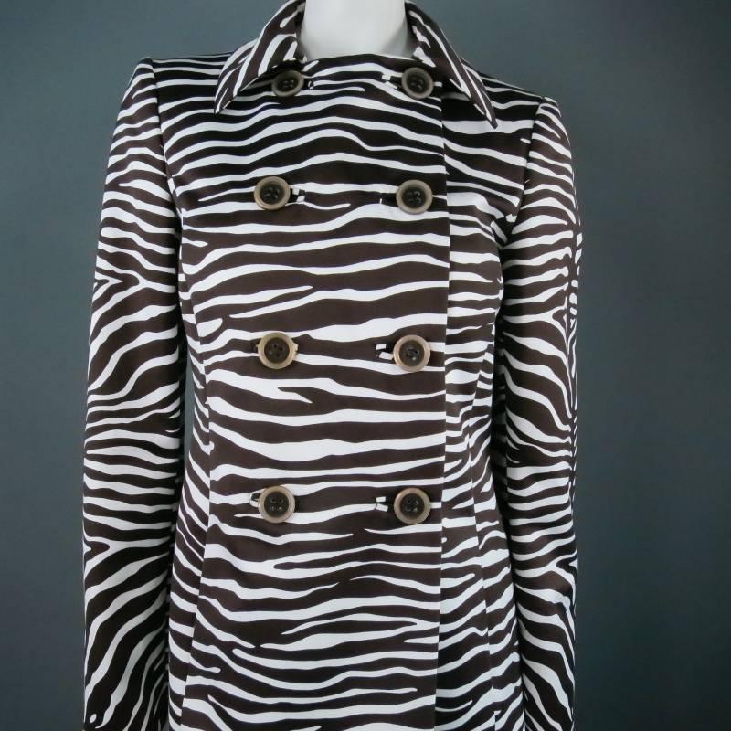 Fabulous double breasted trench coat by Michael Kors. A classic style in a bold brown and white zebra printed cotton silk blend with a subtle sheen, featuring 8 two-tone buttons up to the collar and hidden slit pockets.. A functional piece with high