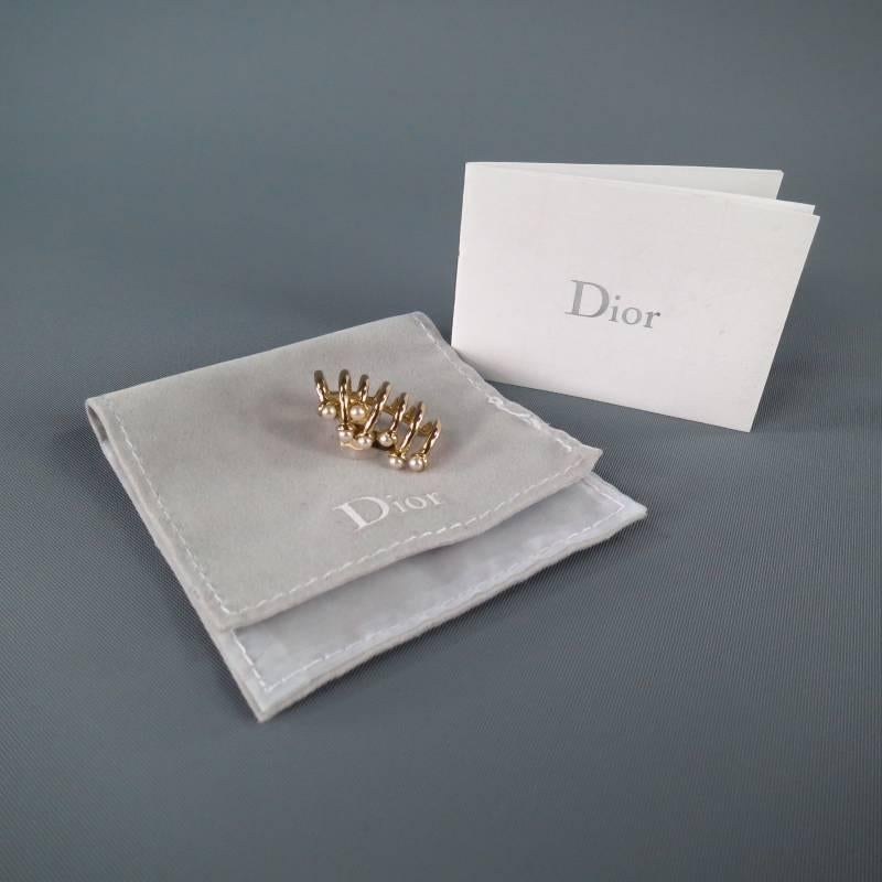 Fabulous cuff earring by DIOR. A modern style in gold tone hardware, this ear cuff features layered bands with with pearl ends and clips on to the upper section of your ear.
 
Excellent Pre-Owned Condition.
 
Length: 1 in.
Width: 0.5 in.
