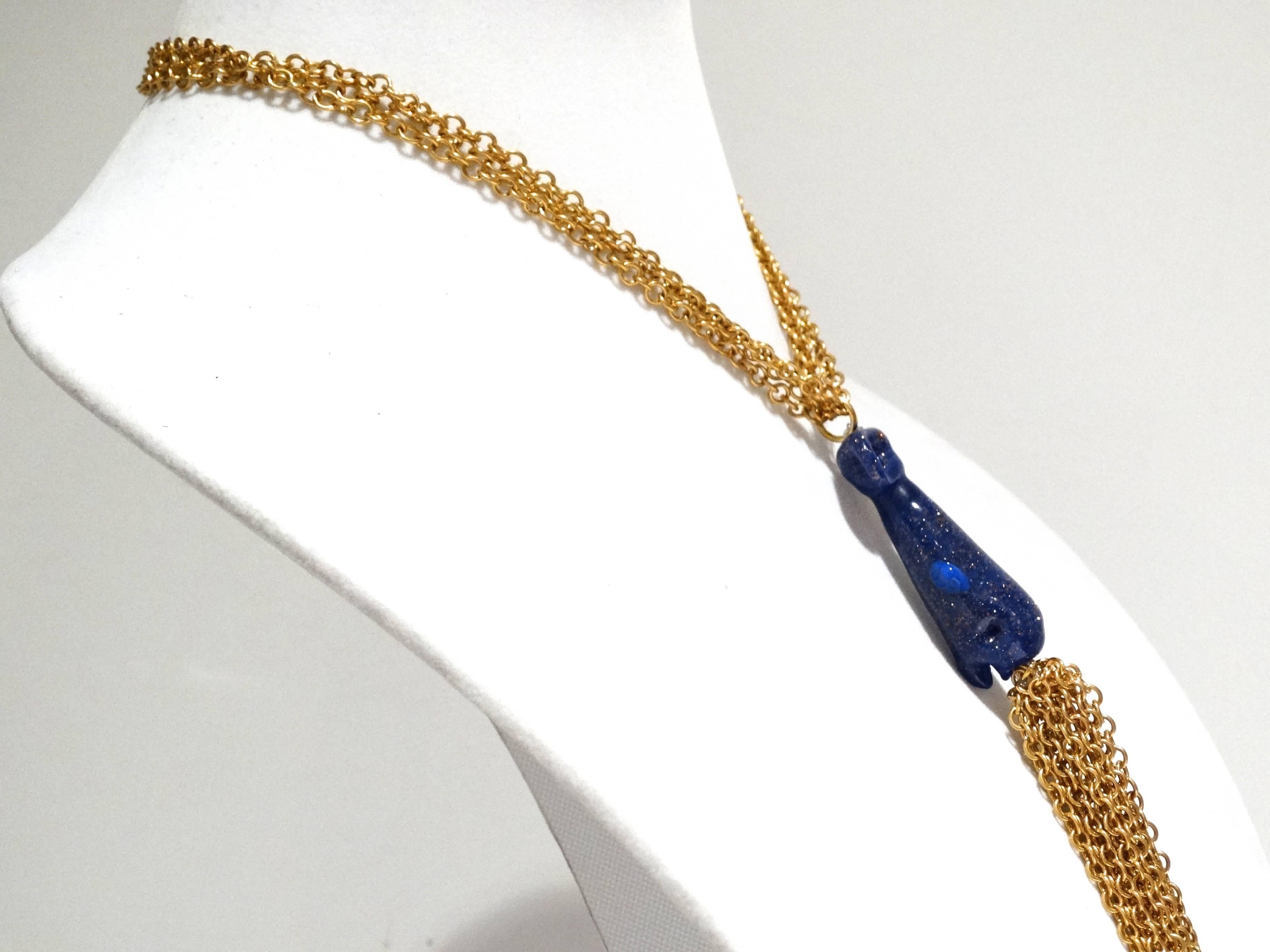 A beautifully sculptured necklace created by William de Lillo in the 70's! This necklace features a blue glass whale sculpture in center of the necklace with 15 gold plated chains hanging from the front of the whale that drop down 8