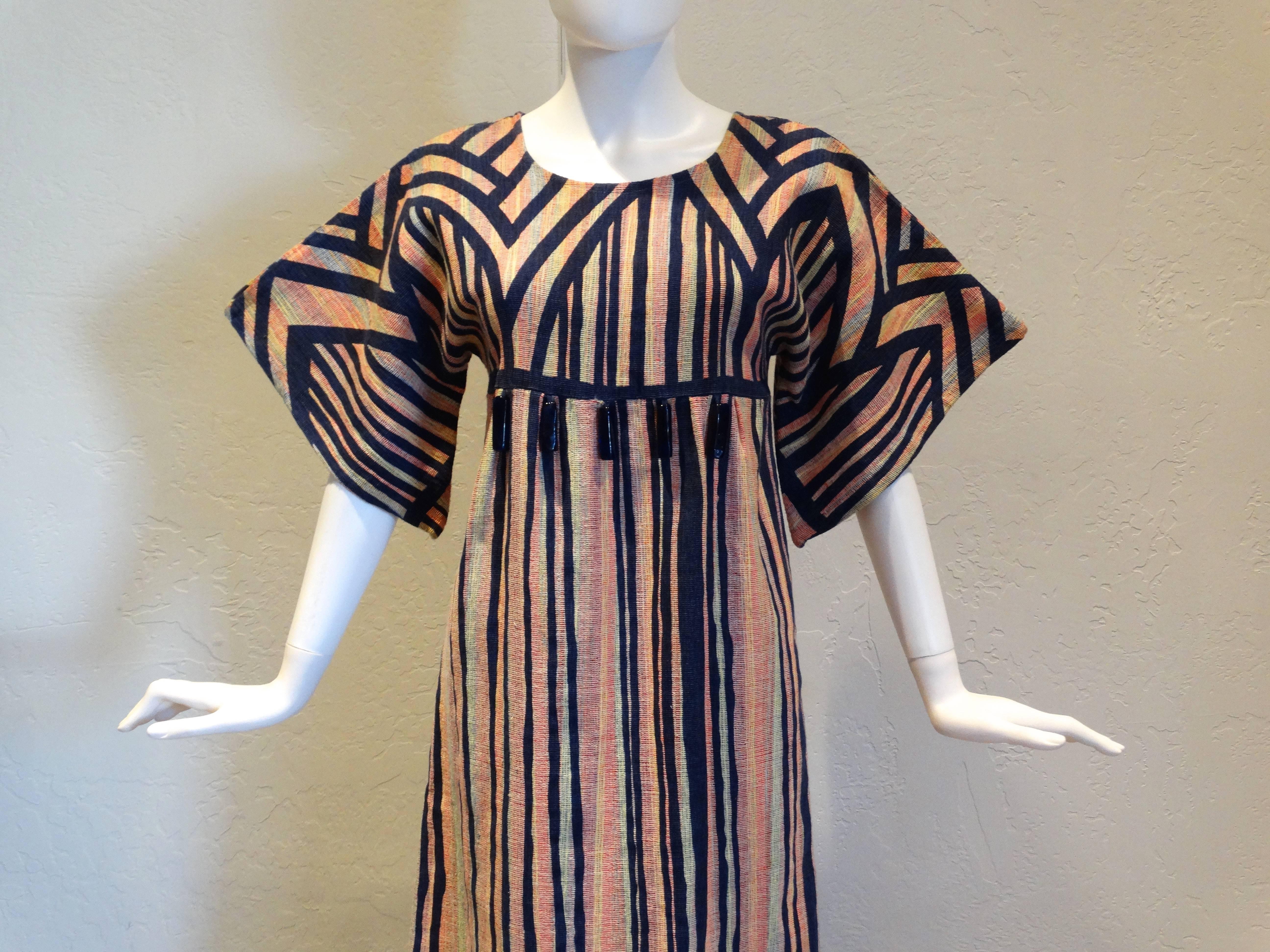 Fabulous bohemian dress circa 1970's by the iconic Israeli RIKMA brand.
The cotton is woven with multiple colours creating a an ethnic folky look. 
The fabric is overprinted with a dark blue line / stripe pattern.There are five solid blue glass