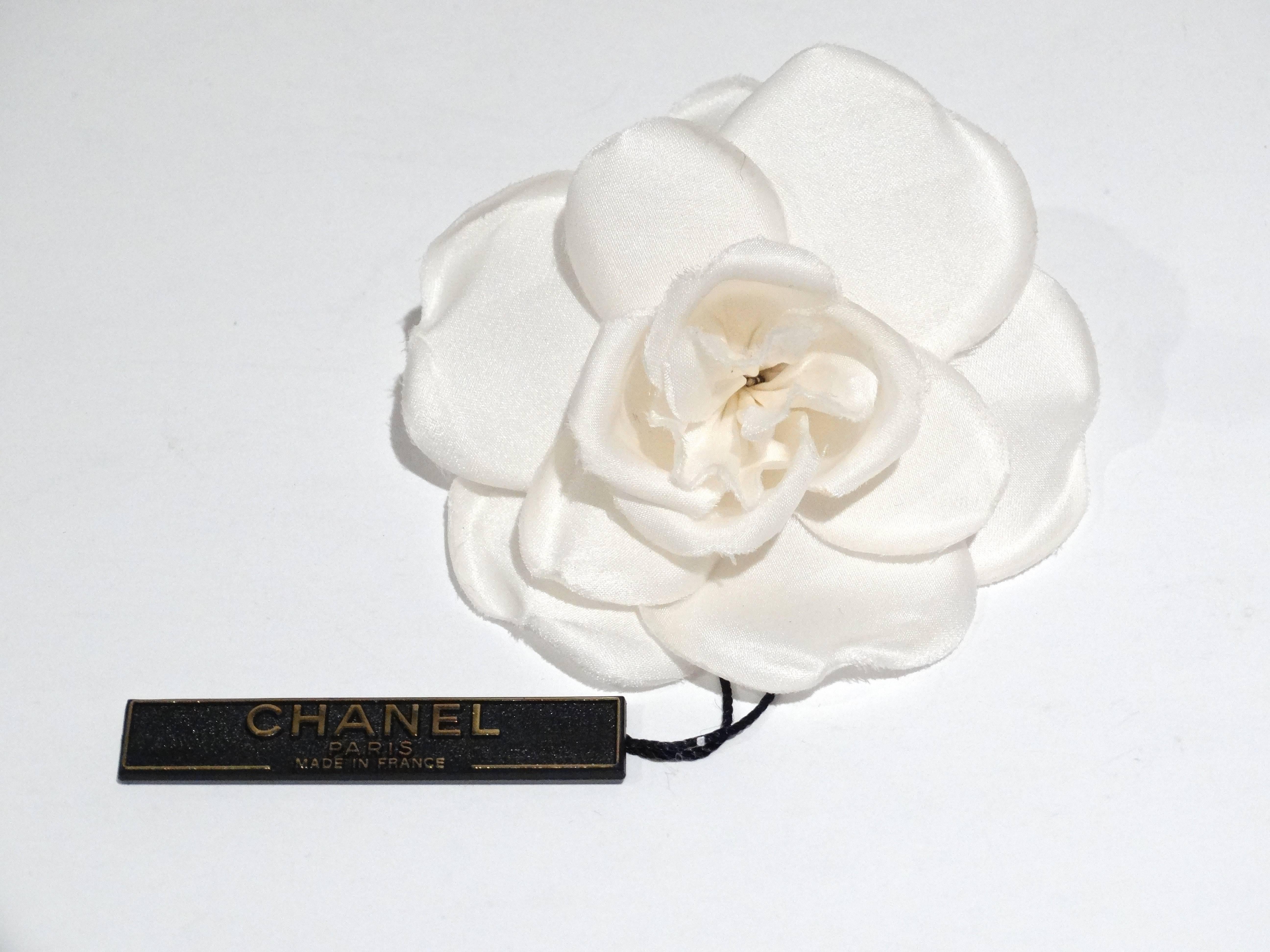 This is an authentic 1996 A CHANEL Fabric Camellia Flower Brooch White. The elegant style and classic quality of this Chanel brooch make an iconic fashion accessory. This is a wonderful pin and a piece of Chanel tradition as Chanel has made the