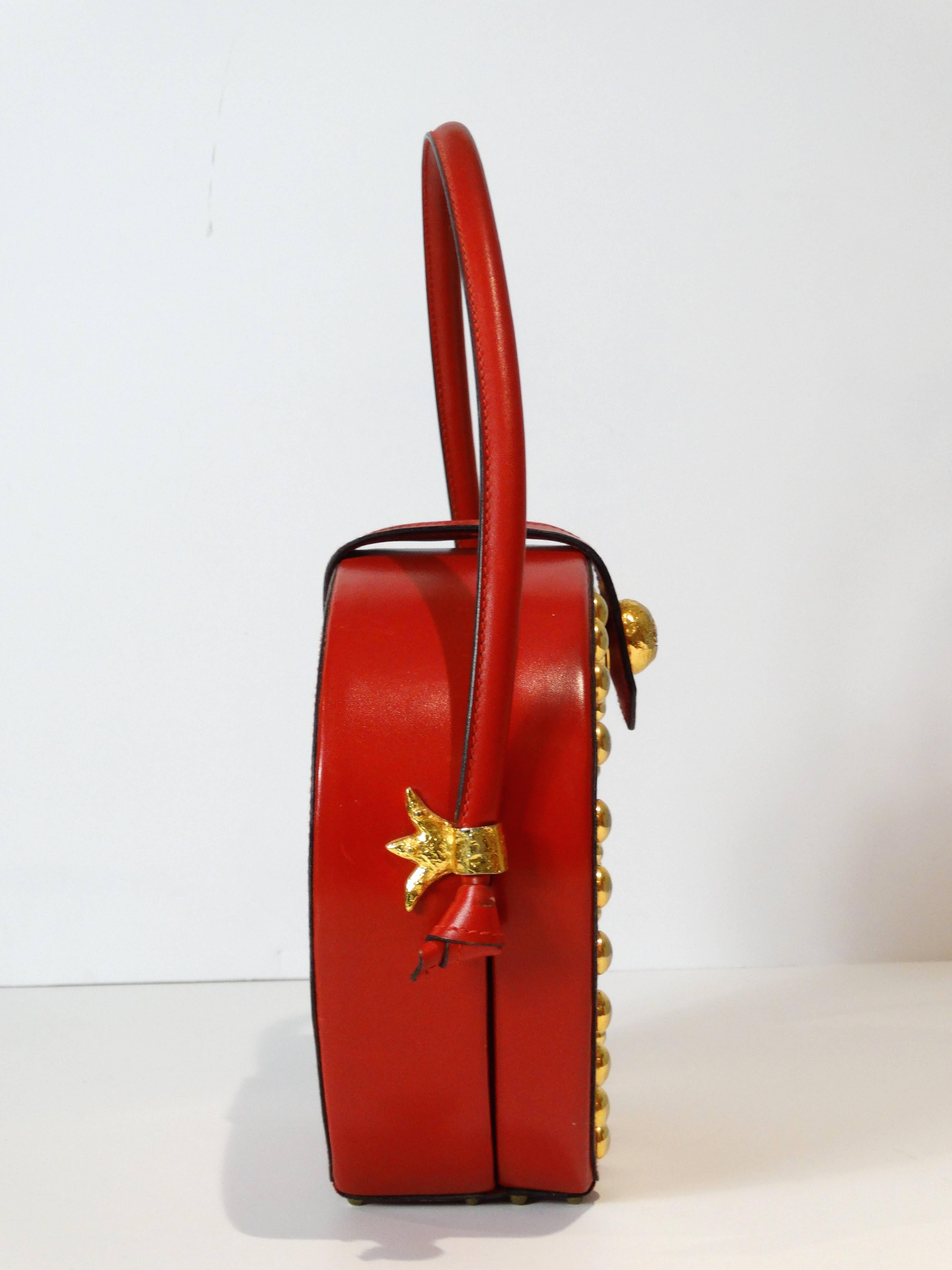 1993 CHRISTIAN LACROIX very rare and exceptional handbag comprising of two red leather top handles, red leather, a cross stud design on the front of the handbag in gold studs. Red lining printed with the CL monogram snap closure comprising of a zip